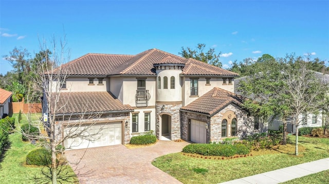 5774 Fulham Pl, Sanford, FL 32771 - mediterranean / spanish-style house featuring driveway, a tile roof, a garage, stone siding, and stucco siding