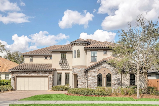 5774 Fulham Pl, Sanford, FL 32771 - mediterranean / spanish-style home featuring an attached garage, a tile roof, stone siding, stucco siding, and driveway