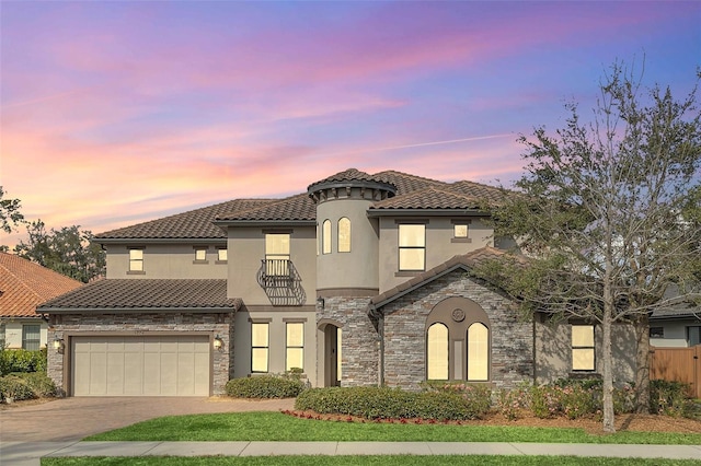 5774 Fulham Pl, Sanford, FL 32771 - mediterranean / spanish-style home featuring a garage, stone siding, stucco siding, a tiled roof, and driveway