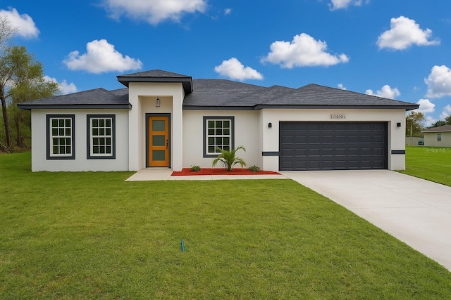 prairie-style home featuring a garage, a front lawn, concrete driveway, a shingled roof, and stucco siding