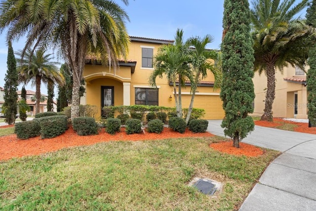 mediterranean / spanish-style house featuring a garage and a front lawn