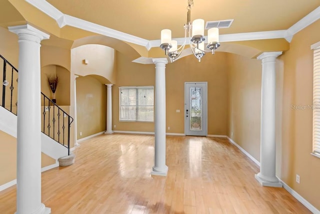 foyer entrance featuring ornamental molding, wood-type flooring, and decorative columns