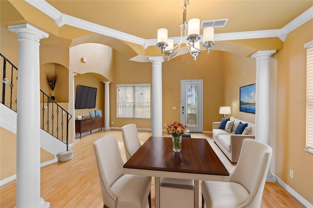 dining room featuring ornamental molding, decorative columns, and light hardwood / wood-style flooring