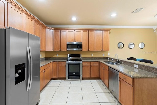 kitchen featuring sink, crown molding, dark stone countertops, appliances with stainless steel finishes, and kitchen peninsula