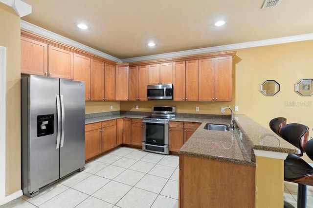 kitchen featuring appliances with stainless steel finishes, sink, a breakfast bar area, dark stone counters, and kitchen peninsula