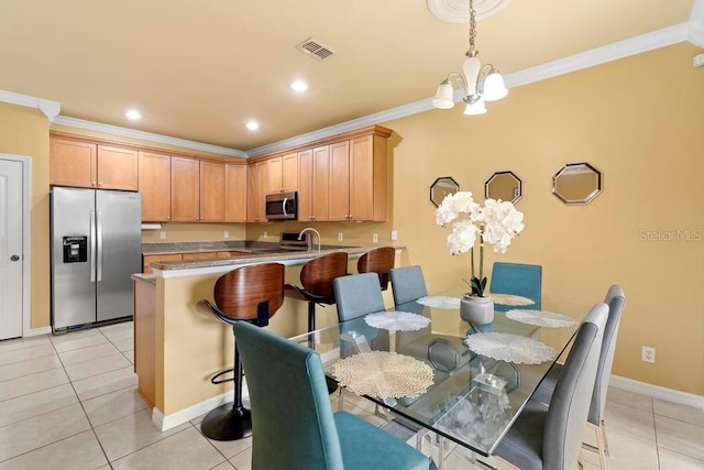 dining room with light tile patterned flooring, ornamental molding, and an inviting chandelier