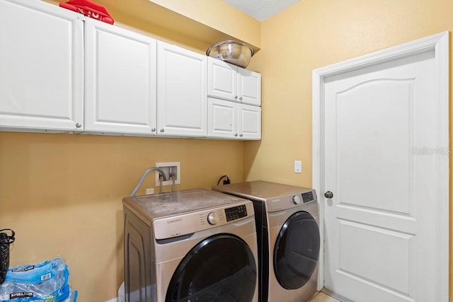 laundry room featuring independent washer and dryer and cabinets