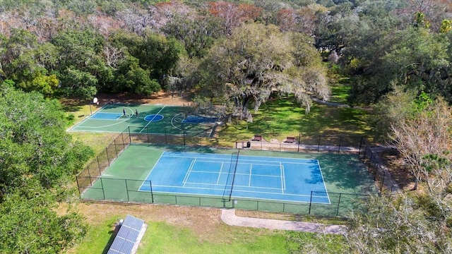 view of tennis court with a yard and basketball hoop