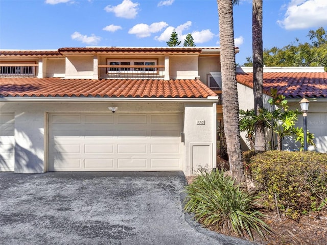 mediterranean / spanish-style home featuring a garage and a balcony