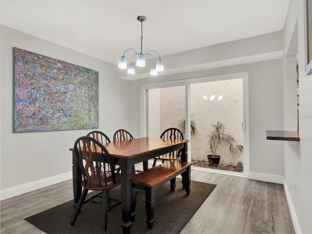 dining area featuring hardwood / wood-style flooring and a notable chandelier