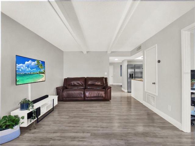 living room with beamed ceiling and hardwood / wood-style floors