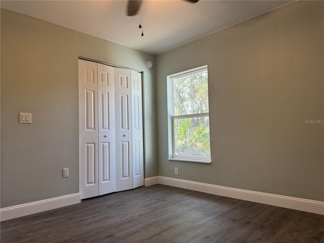 unfurnished bedroom featuring a closet, dark hardwood / wood-style floors, and ceiling fan