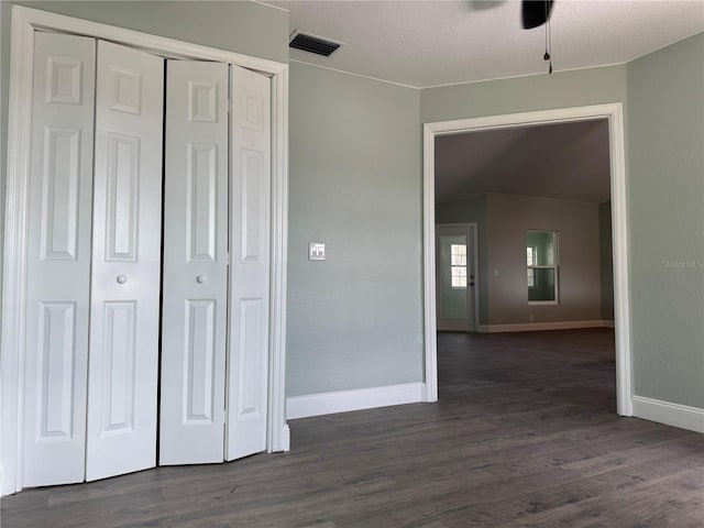 unfurnished bedroom featuring a closet and dark hardwood / wood-style floors