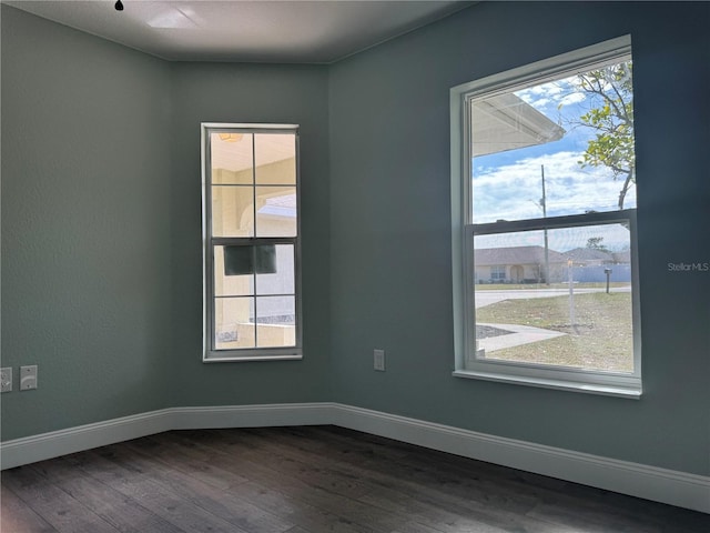 spare room featuring a healthy amount of sunlight and hardwood / wood-style flooring