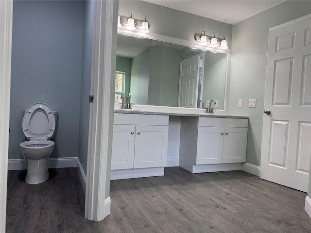 bathroom featuring toilet, wood-type flooring, and vanity