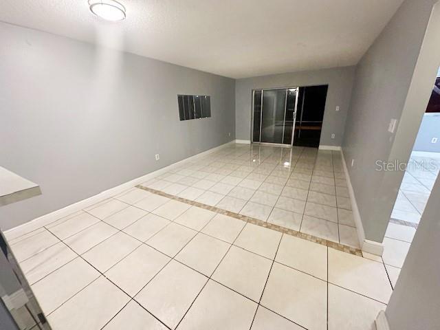 empty room with light tile patterned flooring and baseboards