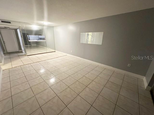 spare room featuring tile patterned flooring, visible vents, and baseboards