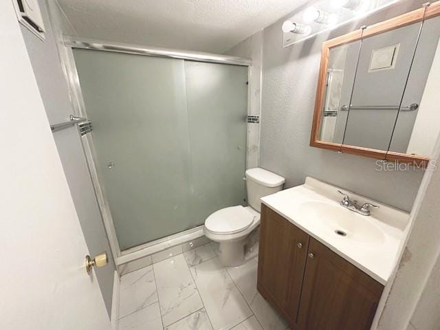 full bath with a textured ceiling, toilet, vanity, marble finish floor, and a shower stall