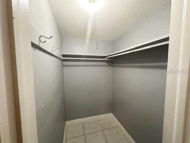 walk in closet with tile patterned flooring