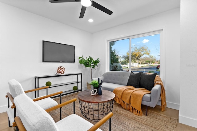 living room with ceiling fan and light hardwood / wood-style flooring