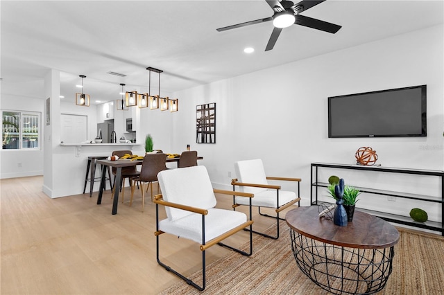 living room featuring light hardwood / wood-style floors and ceiling fan