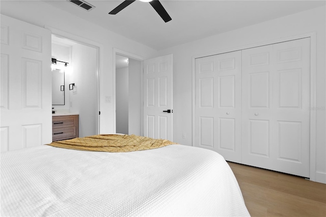 bedroom with light hardwood / wood-style flooring, ceiling fan, and a closet