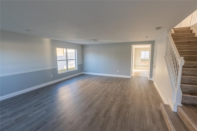 empty room with dark hardwood / wood-style flooring and a textured ceiling