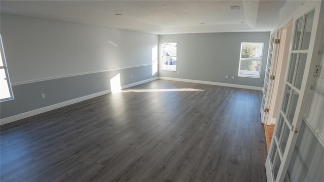 spare room with dark hardwood / wood-style flooring and a textured ceiling