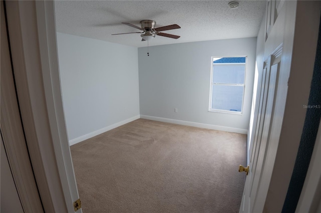 carpeted spare room featuring ceiling fan and a textured ceiling