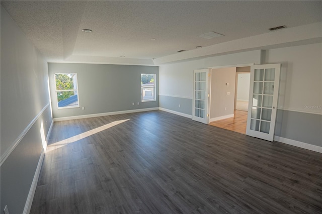 unfurnished room featuring french doors, wood-type flooring, a textured ceiling, and a wealth of natural light