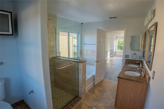 full bathroom with toilet, shower with separate bathtub, a textured ceiling, vanity, and tile patterned flooring