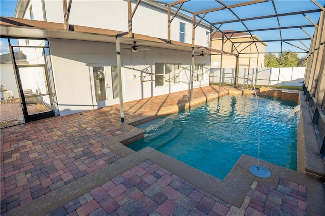 view of swimming pool featuring pool water feature, ceiling fan, a lanai, and a patio area