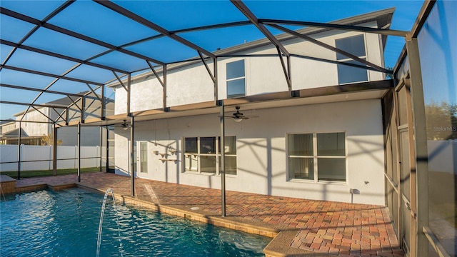 view of pool with pool water feature, ceiling fan, glass enclosure, and a patio