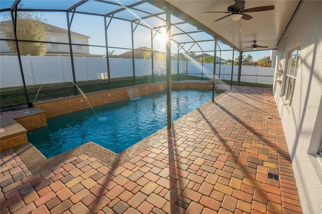 view of pool with pool water feature, ceiling fan, a lanai, and a patio area