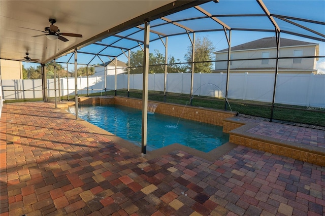 view of pool featuring a patio, pool water feature, ceiling fan, and glass enclosure