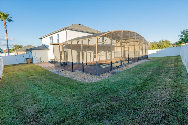 back of property with a lanai and a lawn