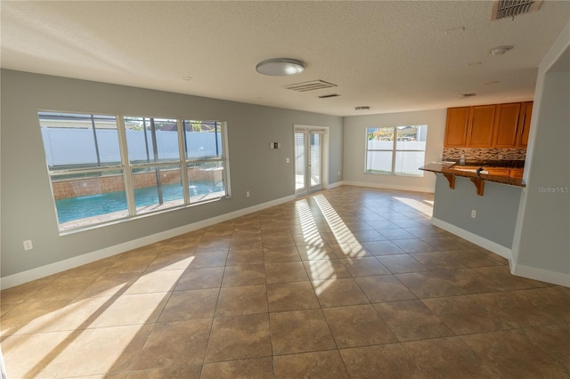 unfurnished living room featuring tile patterned floors and a textured ceiling