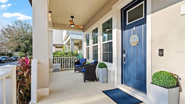 view of exterior entry featuring ceiling fan and covered porch