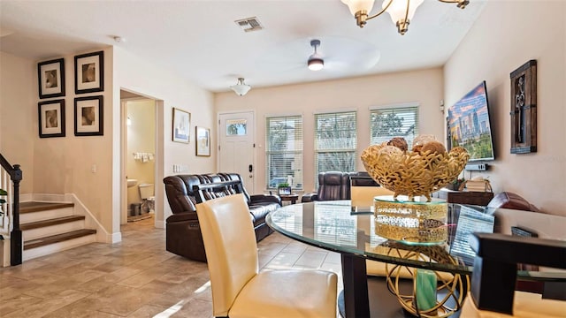 dining area featuring ceiling fan with notable chandelier