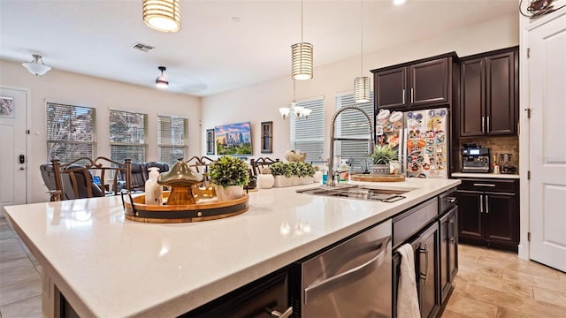 kitchen featuring pendant lighting, sink, dark brown cabinets, a center island, and stainless steel dishwasher