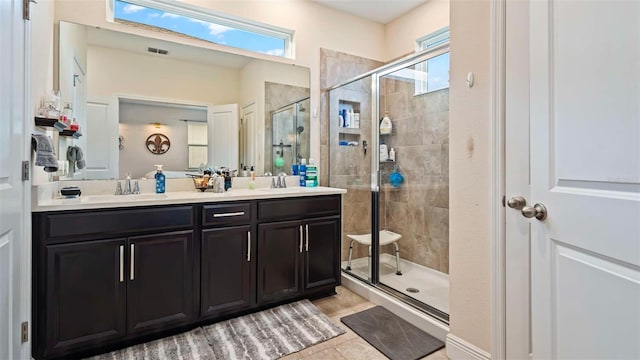 bathroom featuring vanity, a shower with shower door, and tile patterned floors