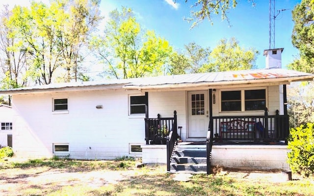 rear view of property featuring covered porch