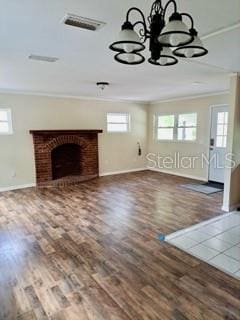 unfurnished living room with crown molding, dark hardwood / wood-style floors, and a fireplace