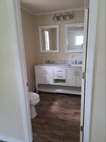 bathroom featuring hardwood / wood-style flooring, vanity, ornamental molding, and toilet