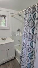 bathroom with shower / tub combo with curtain, wood-type flooring, and vanity