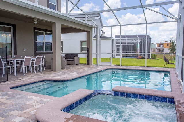 view of swimming pool featuring a patio area, glass enclosure, a yard, an in ground hot tub, and ceiling fan