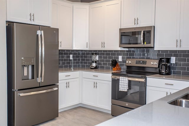 kitchen featuring white cabinetry, tasteful backsplash, and stainless steel appliances