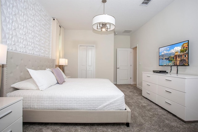 carpeted bedroom featuring an inviting chandelier and a closet