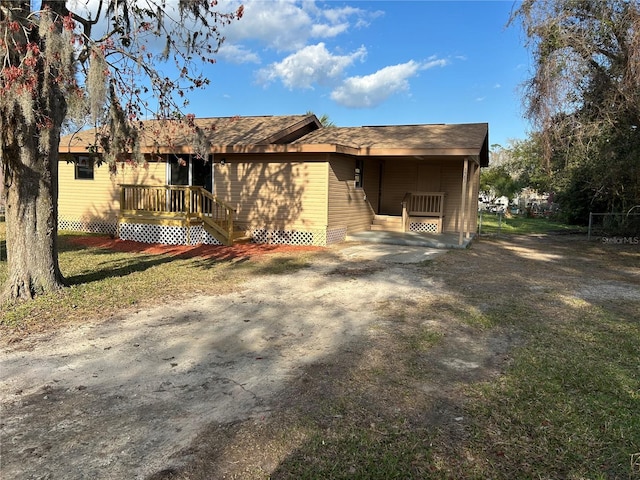 back of property featuring a lawn and a carport