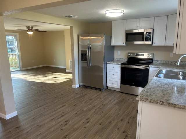 kitchen featuring dark wood-type flooring, sink, a textured ceiling, stainless steel appliances, and white cabinets